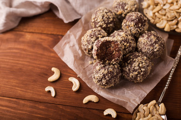 Cocoa balls, chocolate truffles cakes on board on wooden background