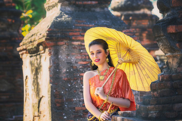 Thai woman wearing period tradition clothes style toothy smiling face and Standing on an umbrella