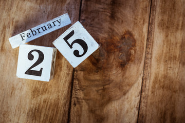 February 25th. Day 25 of February month, white calendar blocks on vintage wooden table background....