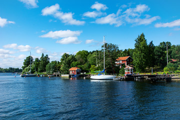 Typical swedish wooden houses and sailboats at the coast in Vaxholm, Sweden