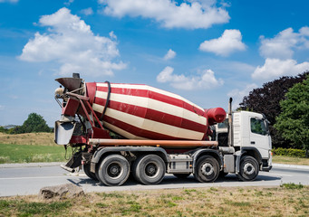 Ein rot/weißer Betonmischer auf der Straße