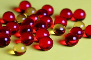 transparent colored capsules on a yellow background