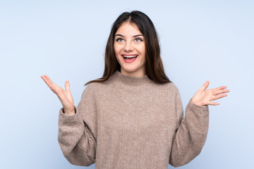 Young brunette woman wearing a sweater over isolated blue background smiling a lot