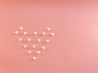 Many harts of sugar, hart shaped on a pink background. Flat lay style.