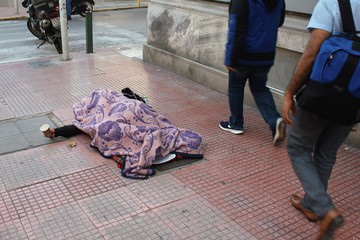 An unidentified homeless person begging for money in the streets of Athens, Greece