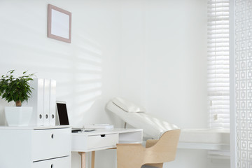 Doctor's office interior with examination couch and desk