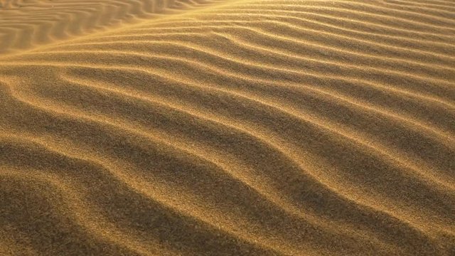 Sand waving in the wind in dunes in desert. Slow motion shot