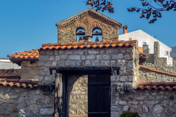 Obraz premium The architecture of the old town in Ohrid. Part of the bell tower and entrance to the courtyard of the Orthodox Church 