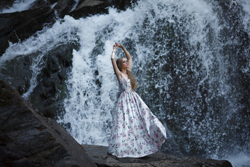 Girl on the background of a waterfall