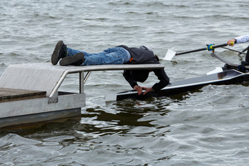 Stakeboat holder on starting platform holding a sport rowing boat.