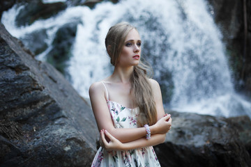 Girl on the background of a waterfall