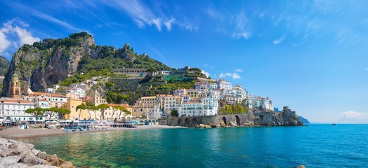 Beautiful Amalfi with hotels on hills leading down to coast, comfortable beaches and azure sea in Campania, Italy.
