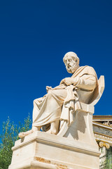 Statue of philosopher Plato near facade of Academy of Athens in Greece. Summer view under deep blue sky