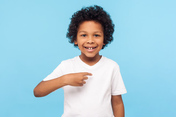 This is me. Portrait of happy preschool curly boy in T-shirt joyfully looking at camera and...