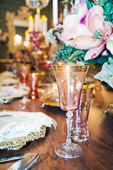 candlestick on the dining table, silver plates, silver forks and wine glass