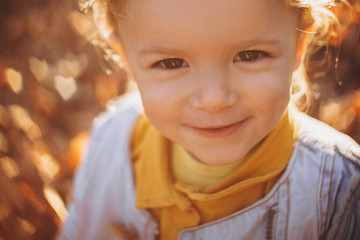 little pretty girl posing for a photo while walking with her parents in autumn park, an infinitely happy and joyful child, selective focus, noise effect