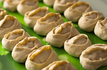 Traditional meat dish of the peoples of Central Asia. National cuisine. Russian cuisine. Minced meat wrapped in a thin dough. Handmade. Traditional Turkish Manti with yoghurt and Vinegar.