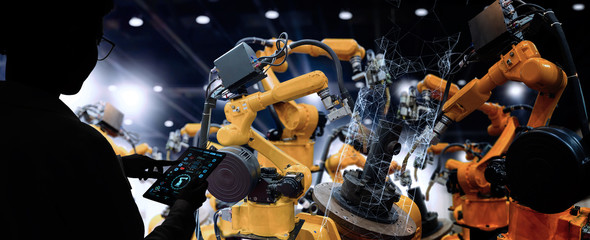 Factory Female Industrial Engineer working with automation robot arms machine in intelligent...