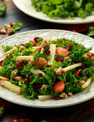Kale salad with dried cranberry, carrots, walnuts and apple. healthy vegan food.