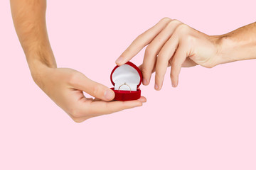 Merry proposal. male hand holds out the engagement ring in red box