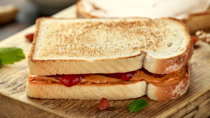 Peanut Butter and strawberry Jelly Sandwich on wooden board. morning breakfast
