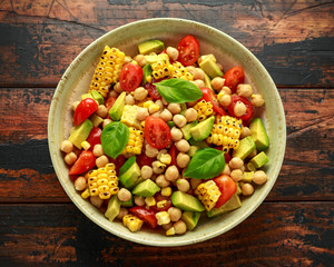 Avocado chickpea salad with grilled sweet corn, tomato and basil. Healthy vegan food
