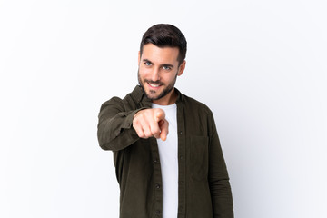 Young handsome man with beard over isolated white background points finger at you with a confident expression