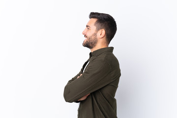 Young handsome man with beard over isolated white background in lateral position