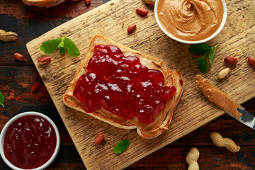 Peanut Butter and strawberry Jelly Sandwich on wooden board. morning breakfast