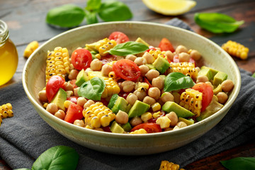Avocado chickpea salad with grilled sweet corn, tomato and basil. Healthy vegan food