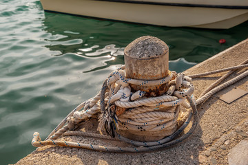 Rope on biteng against the background of water in the port.
