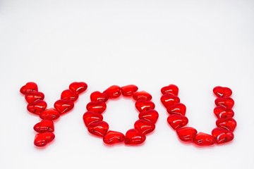 The word YOU, laid out in red hearts on a white background. Copy of the space. Concept of love, Valentine's Day, passion