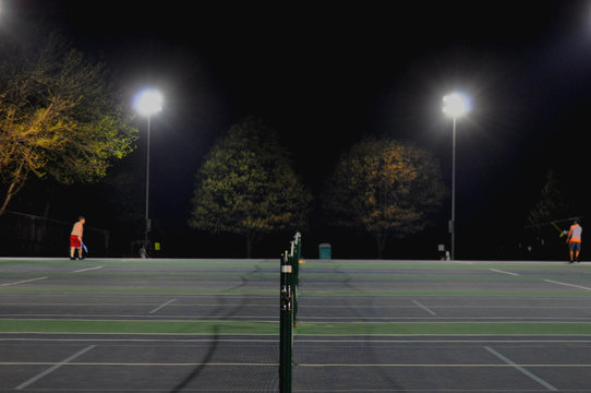 Players At Tennis Court At Night