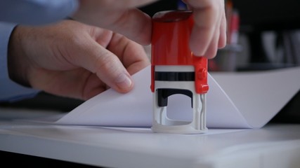 Businessman Hand Stamping Papers and Documents Using a Rubber Stamp, Office Job with Files and Contracts