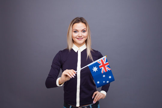 Immigration and the study of foreign languages, concept. A young smiling woman with a Australia flag in her hand