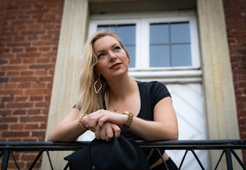 Verträumte junge Frau steht vor einer großen Haustür