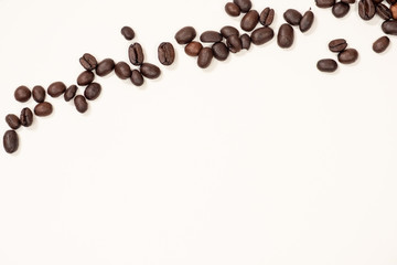 Brown coffee beans on top of a white background