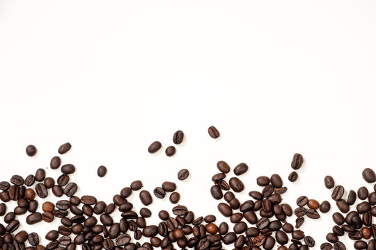 Brown coffee beans scattered downstairs on a white background © Кристина Вертьянова