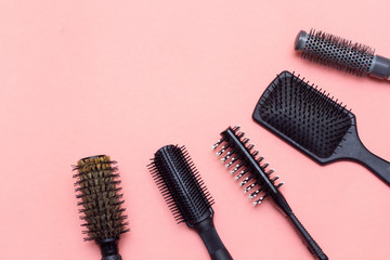 A collection of hairdresser's haircombs. Tools for hair on a pink background