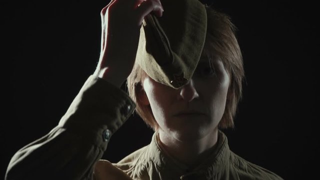 Footage of young woman wearing soviet red army uniform in shadow
