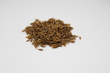 pile of cumin seeds isolated on white background with selective focus