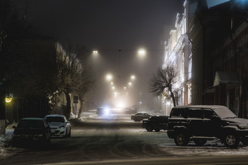 Fototapeta na wymiar dense fog covers the deserted night streets of the city