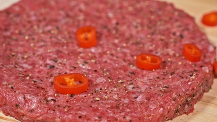 Cook makes meat medallions for burgers. Chef in black food gloves makes cutlet. Cutlets are leveled in steel ring in an even medallion.