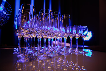 Empty champagne glasses .silhouettes on dark background with blue violet lights