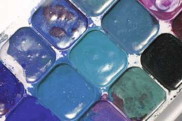 Bright blue, black and green colors mixed in a plastic box. dusty and dirty watercolor. drawing concept. Original creative background