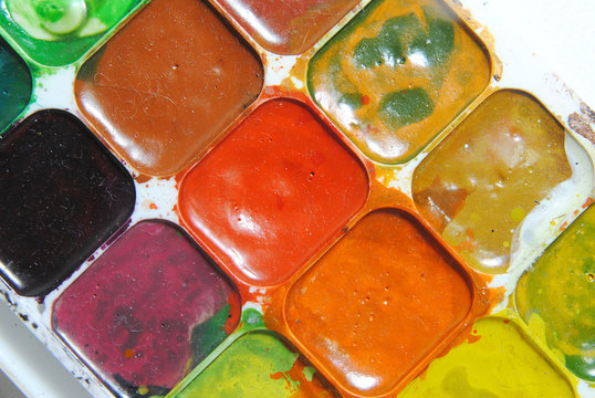 Bright watercolor in a plastic box. dusty and dirty, close-up. drawing concept