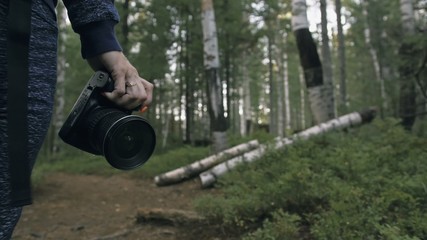 Traveler photographing scenic view in forest. One caucasian woman shooting close up look. Girl hold...