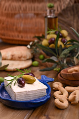 Obraz na płótnie Canvas Greek feta cheese and olives of different varieties. Traditional bread and crocants on a wooden background. Copy space.