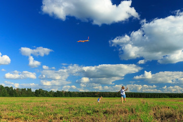 Mother and daughter flying a kite in a field