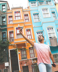 Solo traveler is taking a selfie infront of orange and blue buildings in tourist attraction point. Sightseeeing in a new city. Istanbul.Turkey